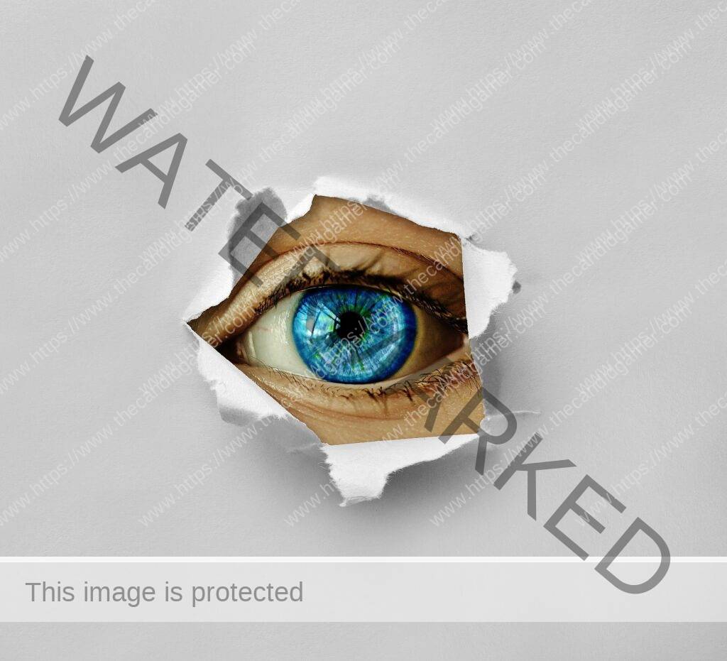 An eye stares through a hole in paper.